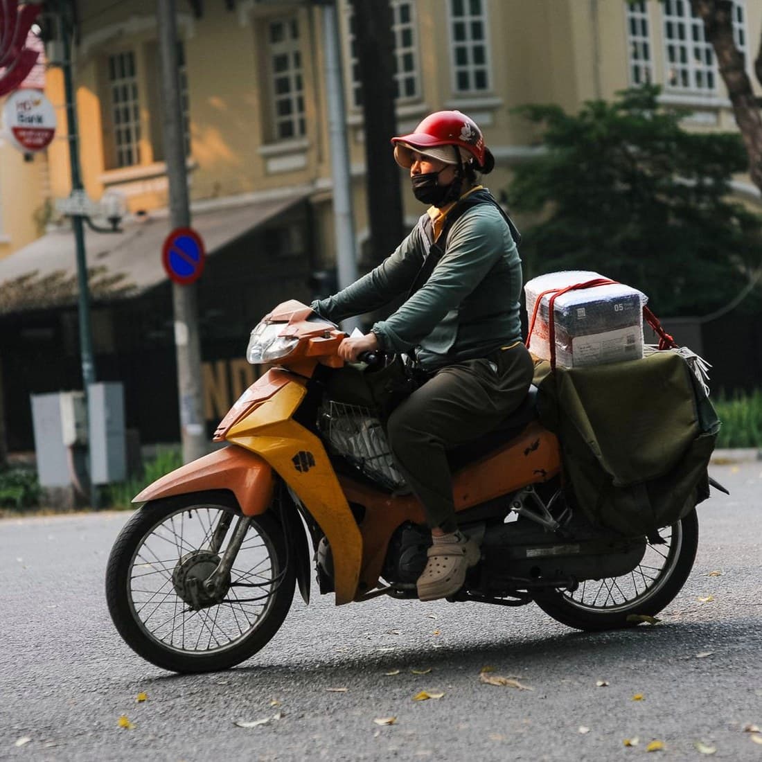 Paket taşıyan bir motokurye, şehir içinde teslimat yaparken